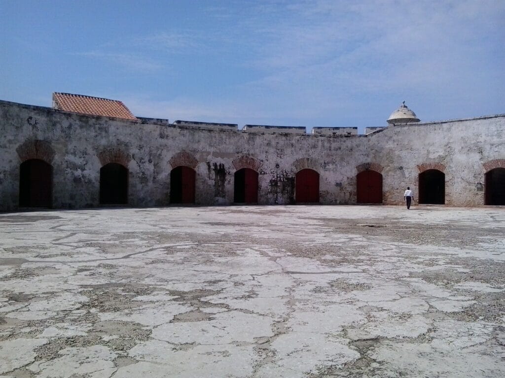 Vista del patio interior del Fuerte de San Fernando en Bocachica, Cartagena, con puertas de piedra y muros coloniales