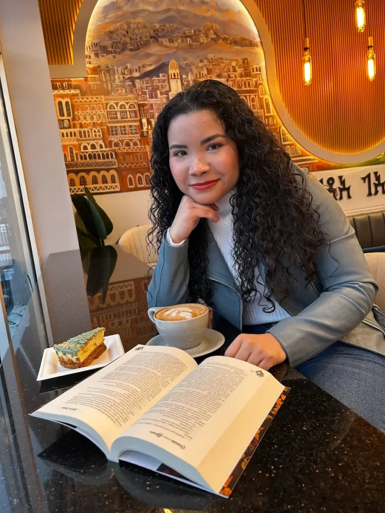 Angélica Madrid, escritora y creadora de La Monarca Azul, leyendo un libro mientras trabaja en nuevas historias de fantasía y reflexiones literarias.